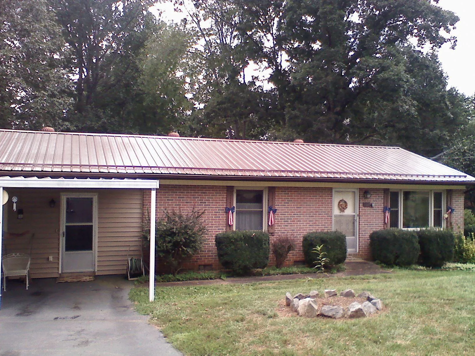 Bronze metal roof and carport on a brick ranch home — Roof Repair work by our crew in Snover